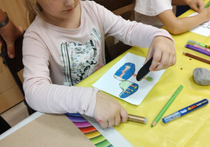 Iza projektuje obrazek, który narysuje na kamieniu