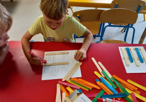 Igorek pilnuje Józia, aby dokładnie rozmieścił patyczki.