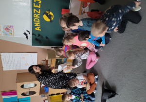 Nauczycielka rozdaje dzieciom ciasteczka z wrózbą.