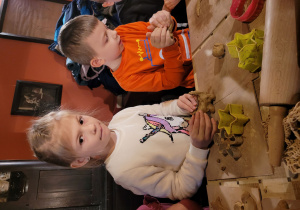 Dzieci tworzą ozdoby choinkowe z gliny.
