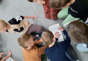 Dzieci w grupach rozszyfrowują hasła.
