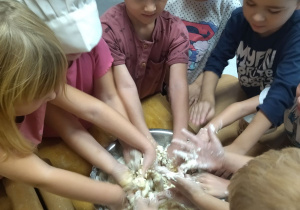 dzieci wyrabiają ciasto rękami