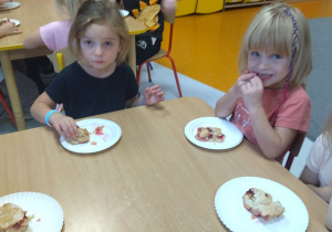 dzieci przy stoliku jedzą ciasto