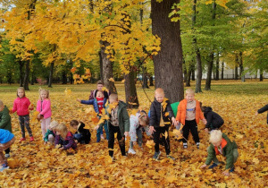 dzieci rzucają liście
