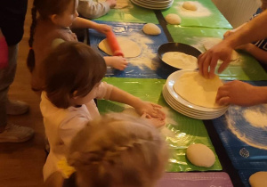 Dzieci wałkują ciastio na pizzę