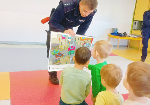 Dzieci ogladają plansze demonstracyjne przedstawiające ruch uliczny.