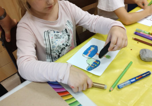 Iza projektuje obrazek, który narysuje na kamieniu