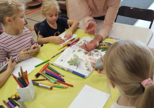 Pani tłumaczy dzieciom, jak wykonać pracę