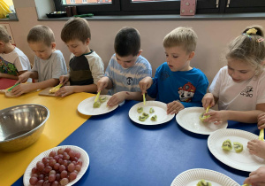 dzieci przygotowują sałatkę