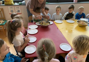 dzieci przygotowują sałatkę