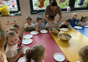 dzieci przygotowują sałatkę