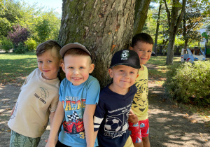 Chłopcy stoją przy drzewie