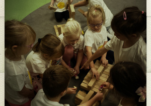 Dzieci wspólnie tworzą drewniane budowle