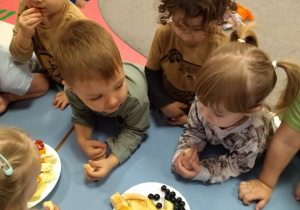 dzieci częstują się owocami i warzywami