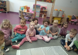 dzieci na dywanie oglądają flagę