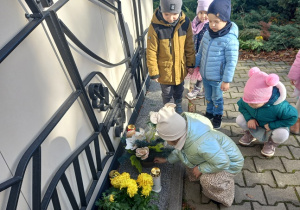 Dzieci zapalają światełko pamięci.
