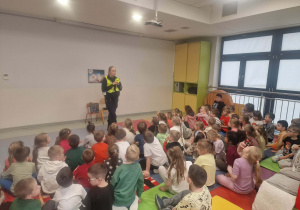 dzieci z zaciekawieniem słuchają Pani policjant