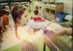 Ala roznosi dzieciom posiłek