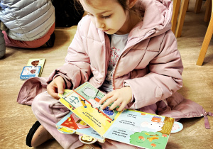 Dziewczynka ogląda ilustracje w książce