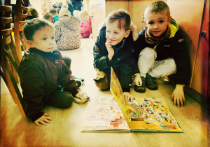 Chłopcy oglądają ilustracje w książce