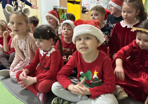 Dzieci siedzą na dywanie