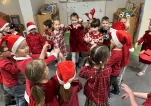 Dzieci śpiewają i tańczą dla Mikołaja