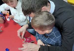 Dzieci wraz z rodzicami tworzą ozdoby świąteczne