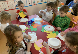 Dzieci wykonują pracę plastyczną z papierowych talerzyków