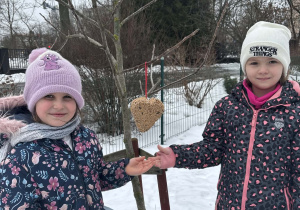 Dziewczynki prezentują ptasią stołówkę
