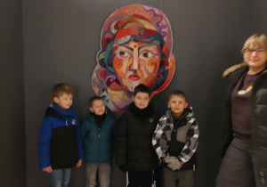 Chłopcy z panią pozują przy patchworku