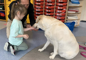 Marcysia karmi smakołykiem pieska