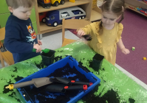 dzieci wsypują ziemię do doniczek