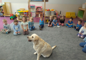 dzieci siedzą wokół psa