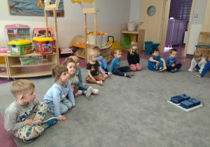 dzieci siedzą na dywanie