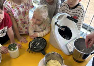 Dzieci uczestniczą w procesie przygotowywania masła