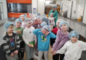 Dzieci pozują do zdjęcia w hali produkcyjnej