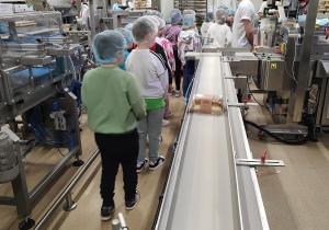 Dzieci przechodzą obok taśmy produkcyjnej