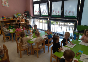 dzieci wykonują zadanie przy stolikach