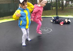dzieci skaczą na trampolinie