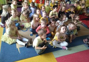 dzieci siedzą na dywanie