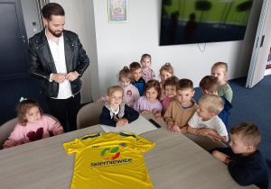 Dziewczynki podpisują koszulkę swoim autografem.