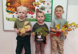 Dzieci pozują z zebranymi liśćmi