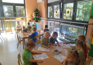 dzieci kolorują przy stolikach