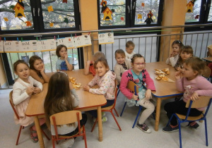 dzieci przy stolikach jedzą produkty ekologiczne