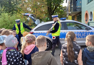 Dzieci z zaciekawienem słuchają policji.