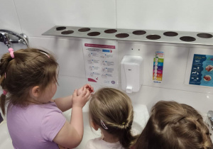 Dziewczynki myją ręce według instrukcji