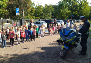 dzieci na dworze oglądają policyjny motor