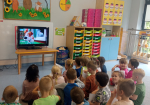 Przedszkolaki siedzą przed telewizorem