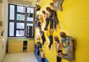 Dzieci wykonują ćwiczenie prezentowane przez trenerkę.