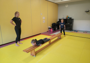 Dzieci wykonują zestaw ćwiczenie prezentowane przez trenerkę.